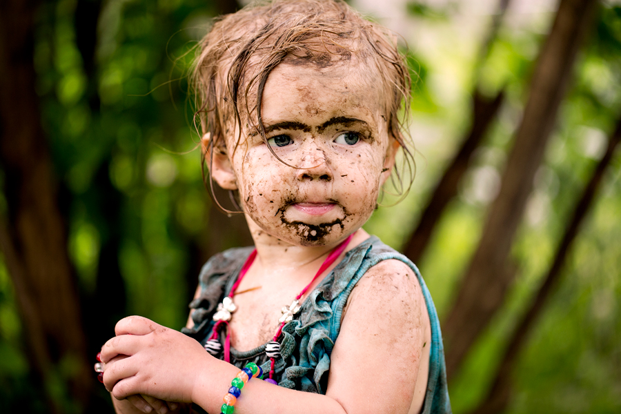 toddler girl with mud in her eyebrows and a mud beard