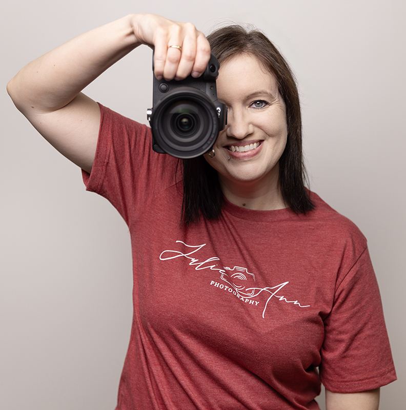 Self Portrait of Julie Nack holding her camera up like she is taking a picture