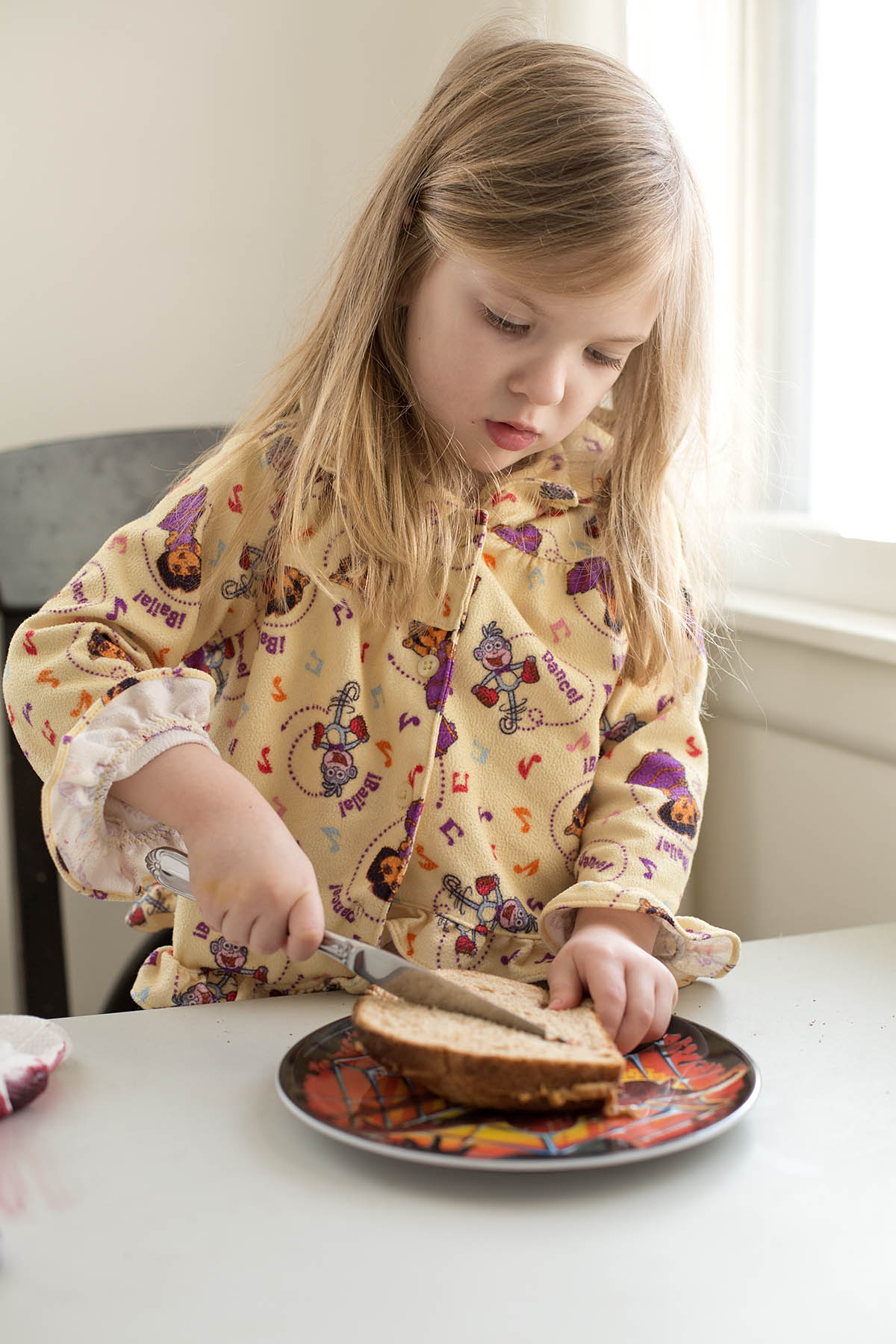 Little girl making her own Peanut Butter and Jelly sandwich at a core memory photo session