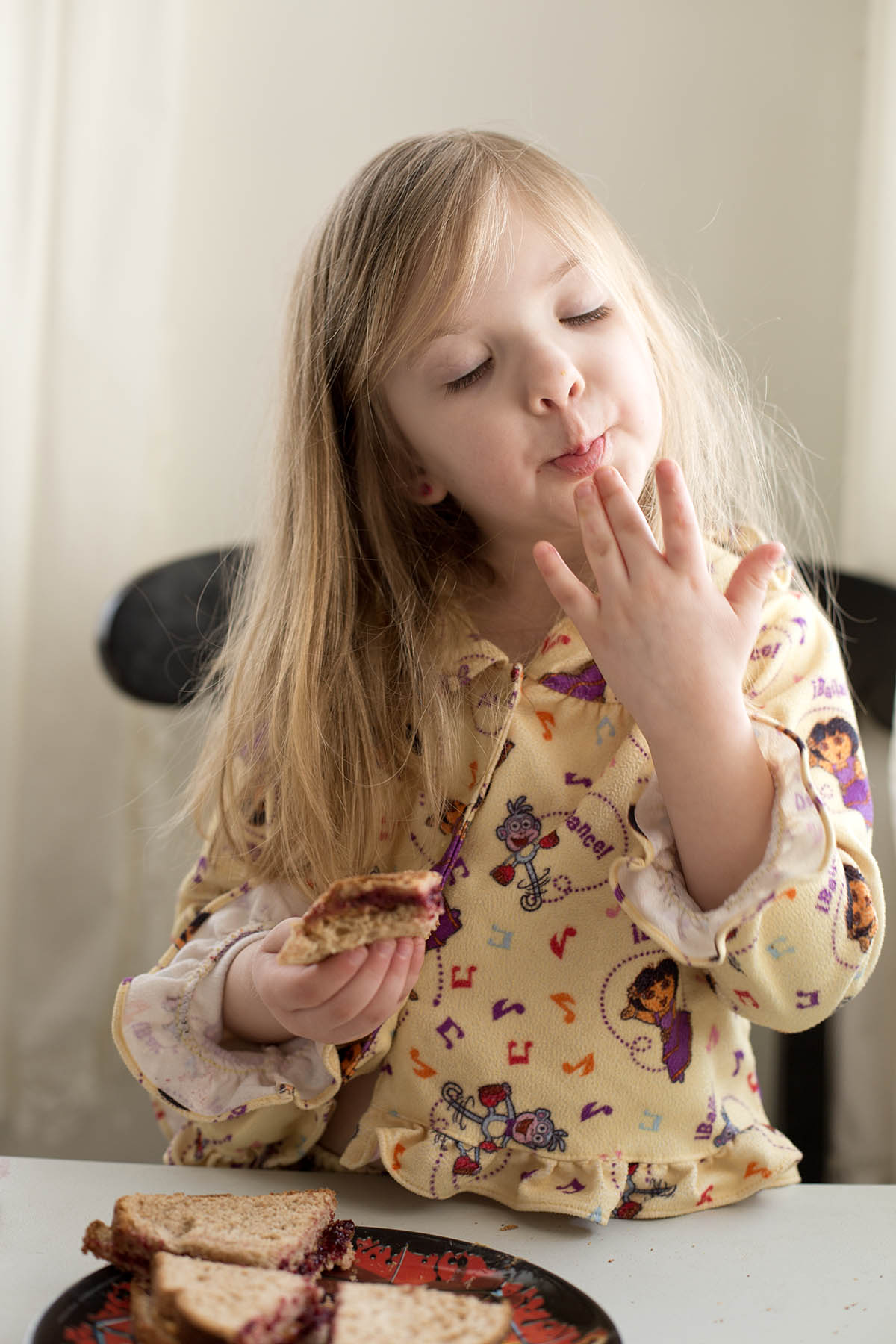 Little girl making her own Peanut Butter and Jelly sandwich at a core memory photo session