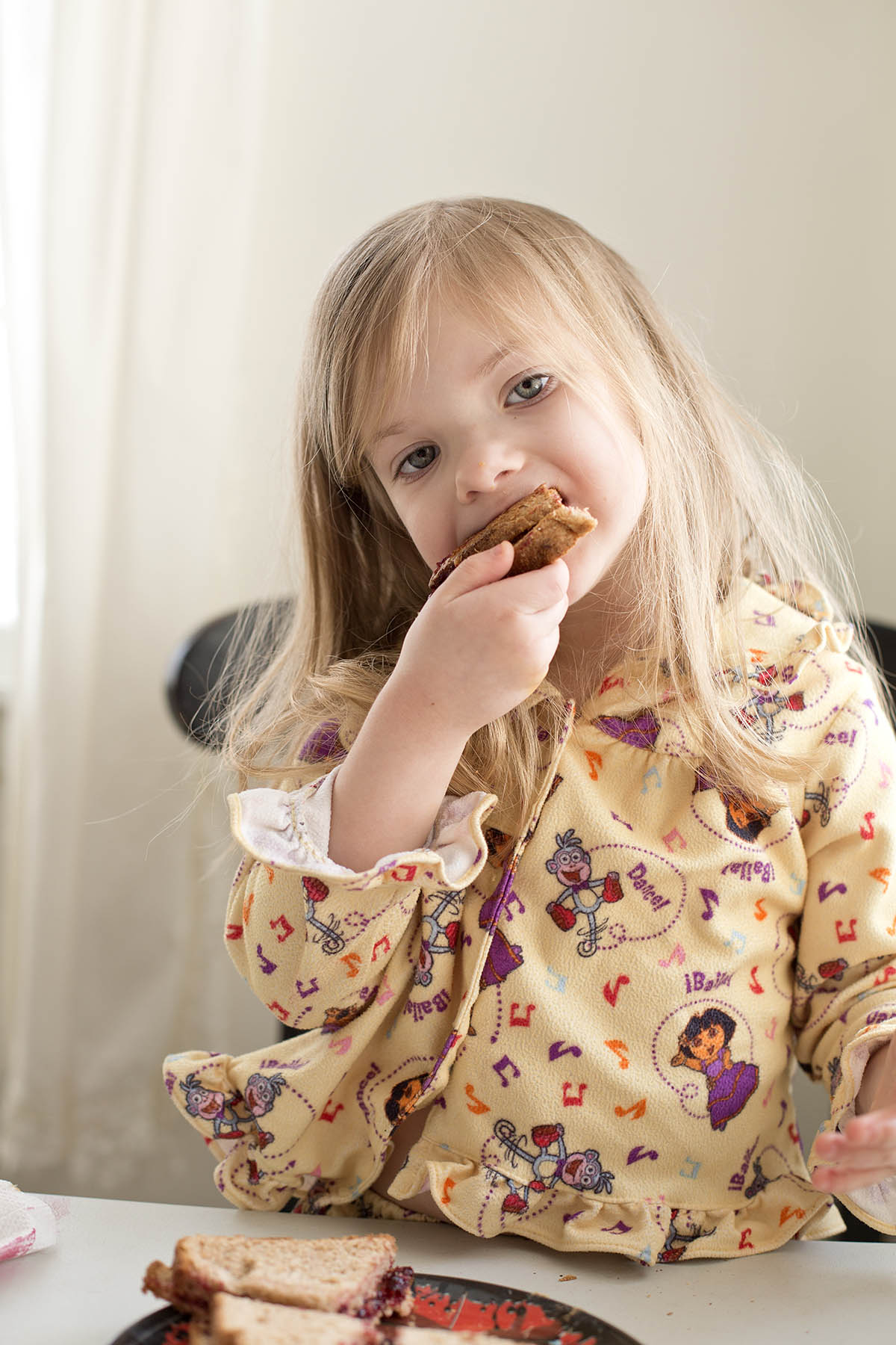 Little girl making her own Peanut Butter and Jelly sandwich at a core memory photo session
