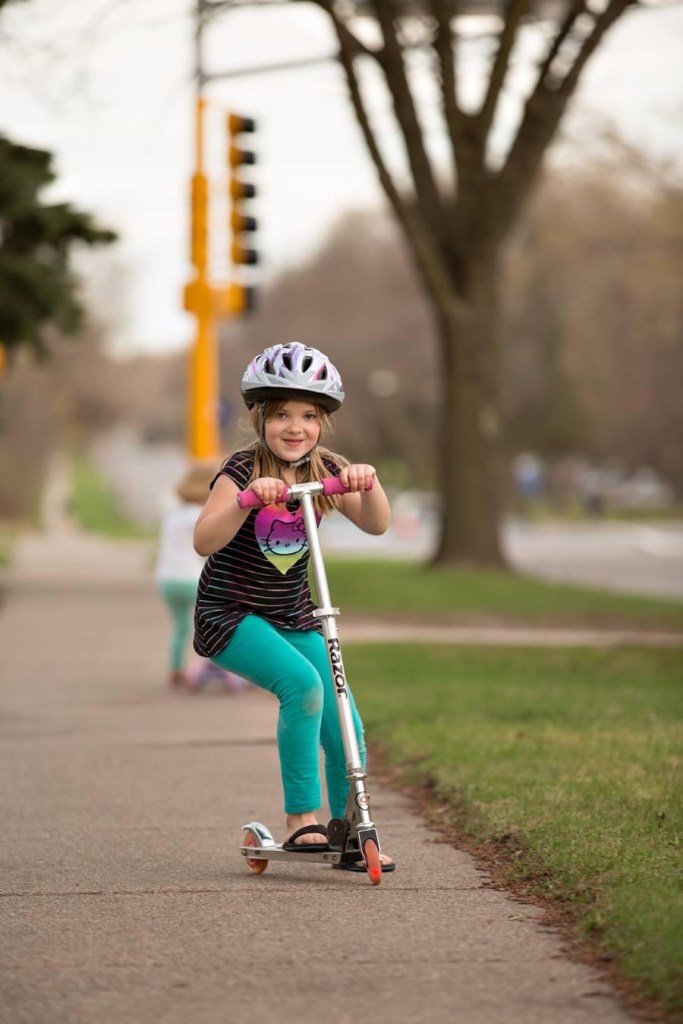Little girl riding a scooter