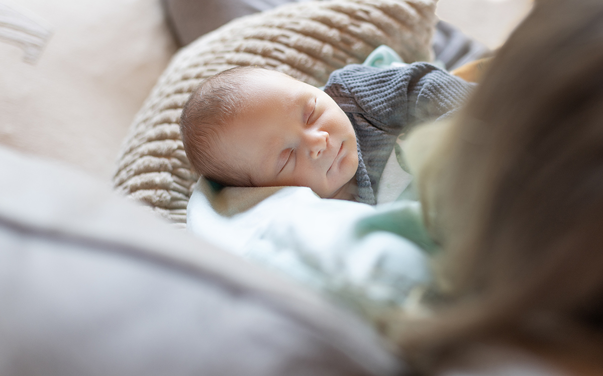 Mom holding baby cozy on the couch