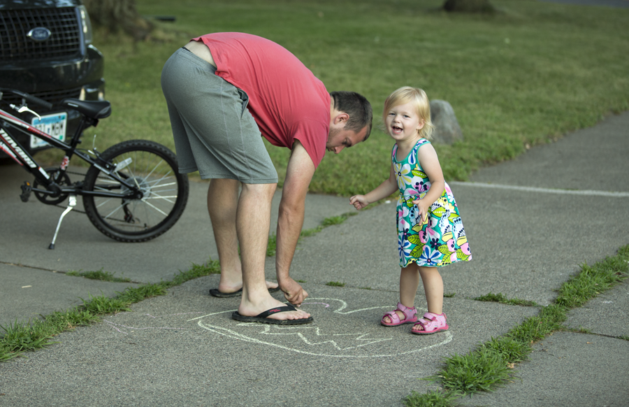 dad and toddler having fun with sidewalk chalk