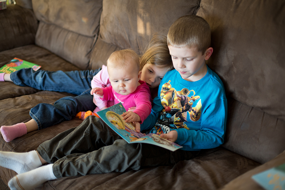 Siblings enjoying reading books together
